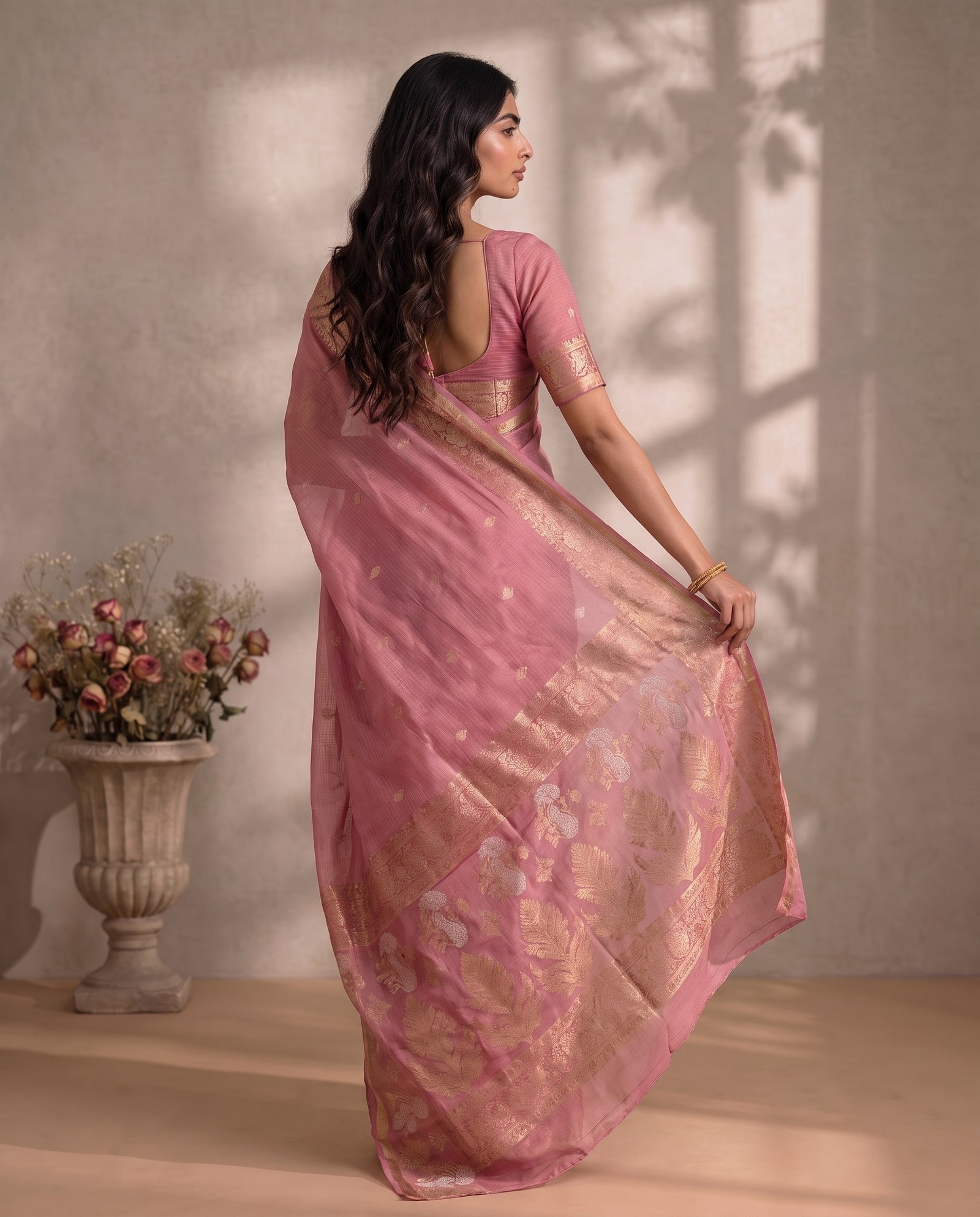 Mid-body crop showing zari butis on pink Manipuri Kota fabric