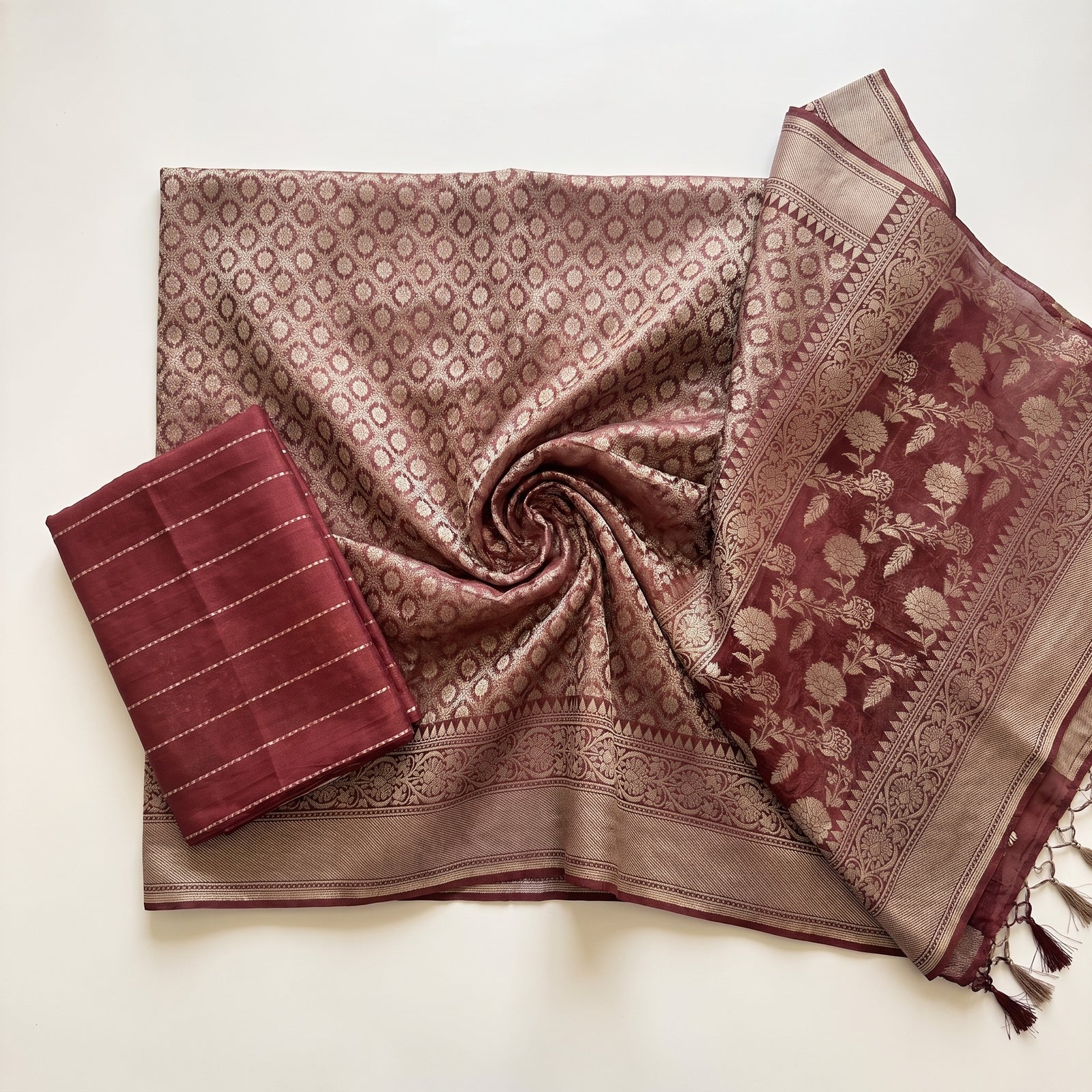 Mid-body crop showing floral zari weaving on maroon pure kora Banaras saree