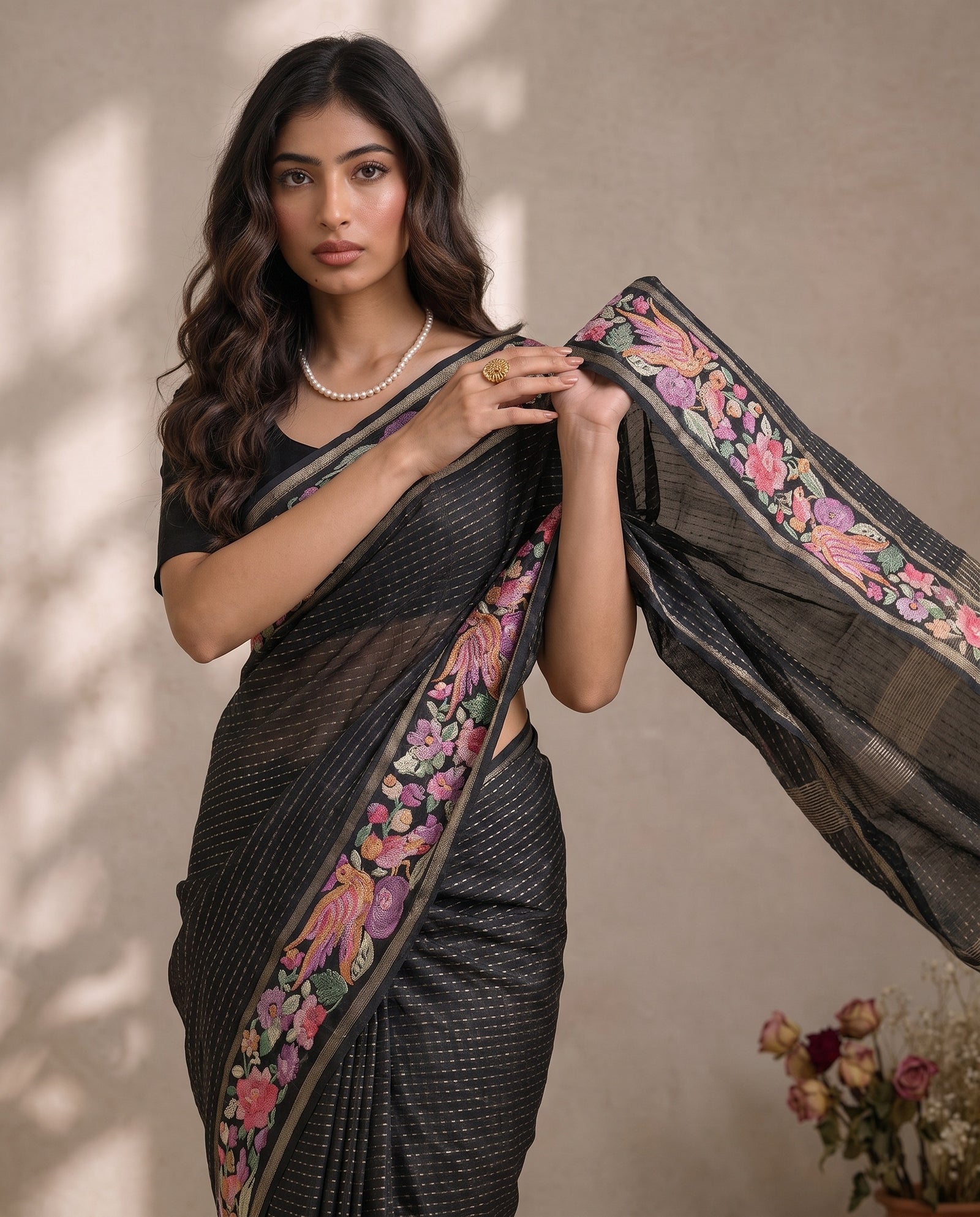 Black pure tussar pallu draped over the shoulder with multi-colour border