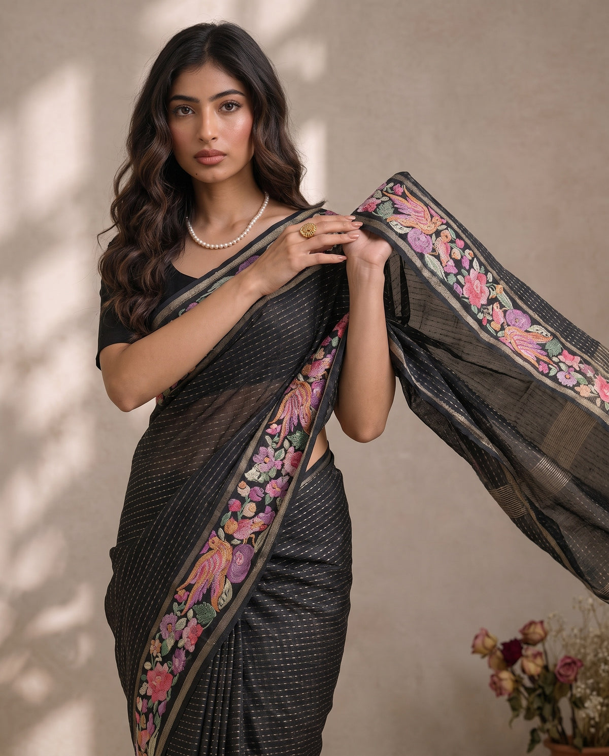 Black pure tussar pallu draped over the shoulder with multi-colour border
