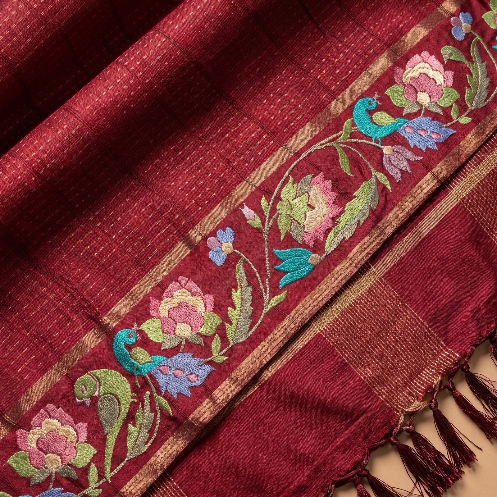 Folded deep pink pure Kosa Tussar saree showing multicolour border and tassels