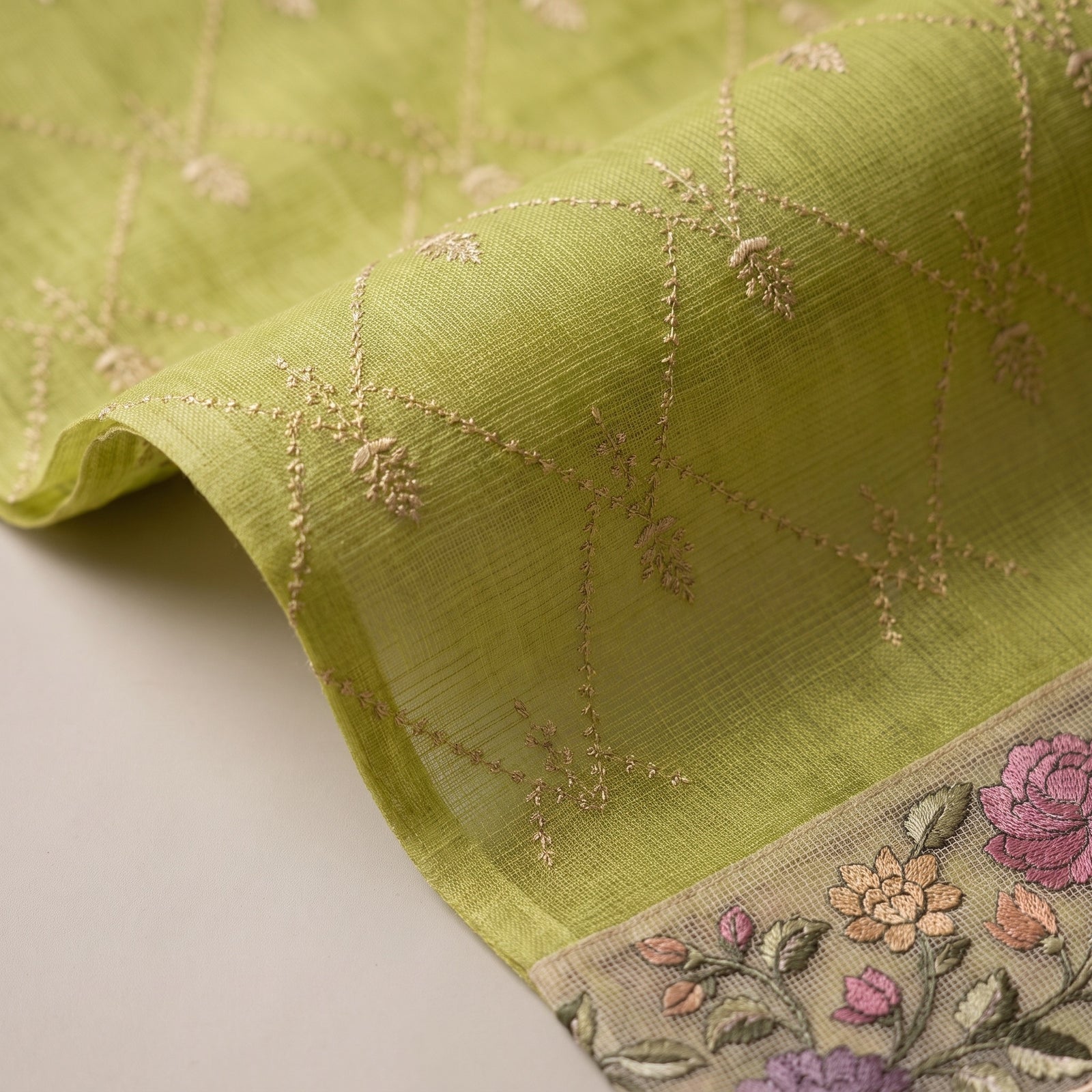 Folded view of green pure kota silk saree highlighting the scalloped floral border