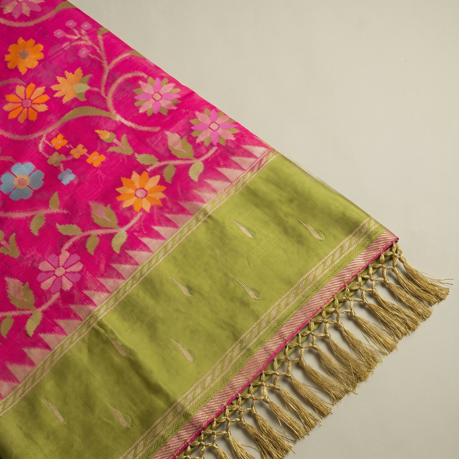 Flat spread view showing the pink body, woven motifs, and olive green pallu