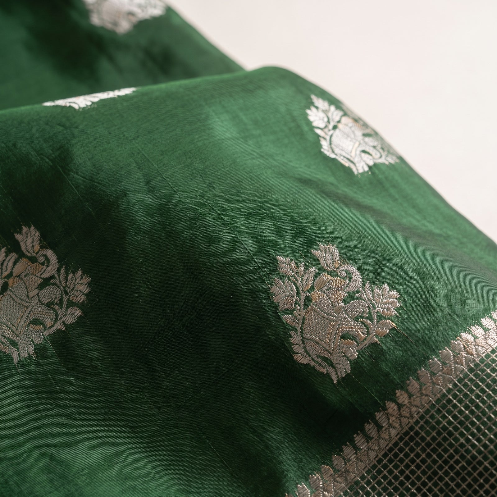 Flat spread view of green pure HO silk saree showcasing body and pallu