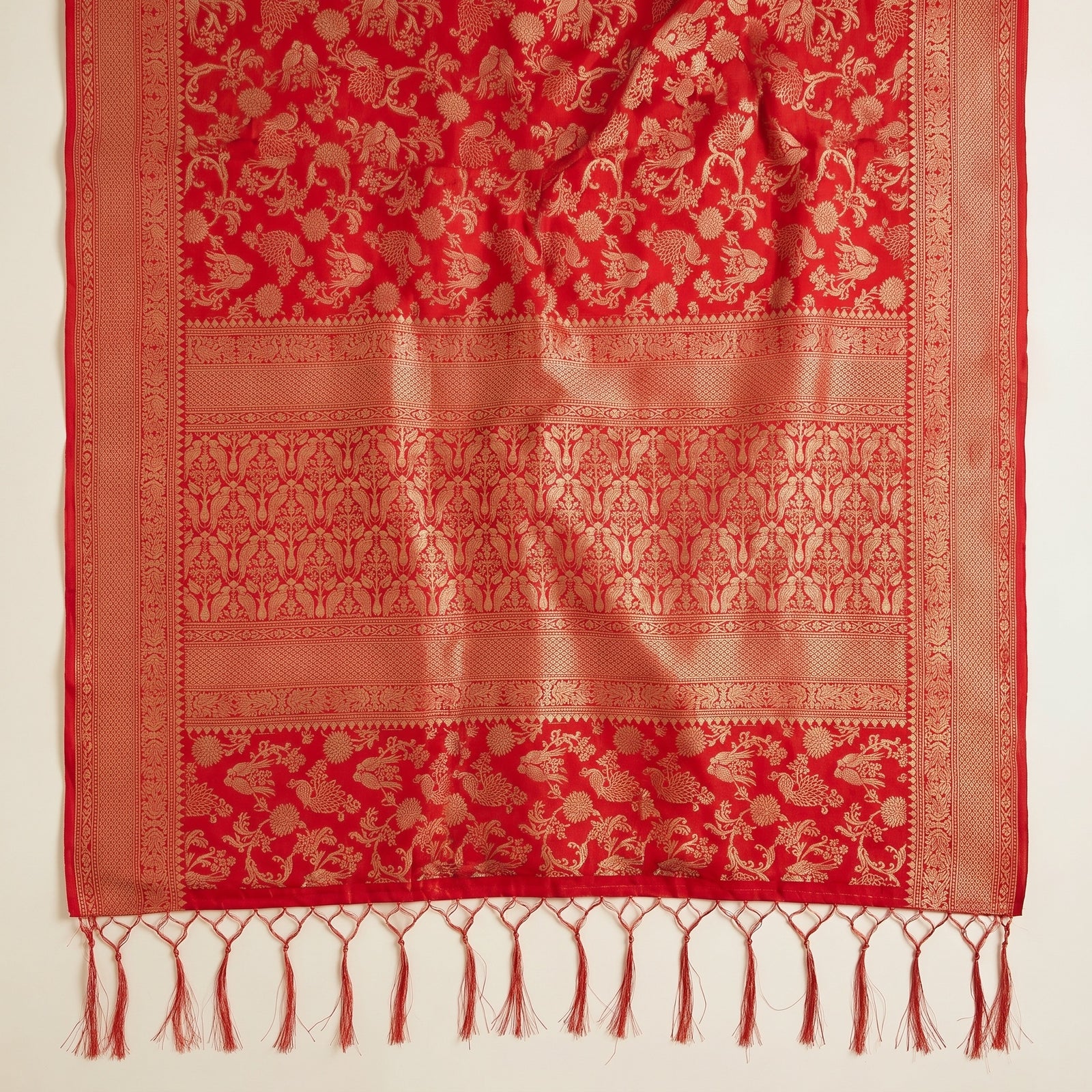 Detailed weave macro of bird and floral motifs on red silk